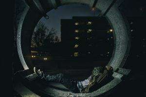 Person laying in a hallway with a building in the background