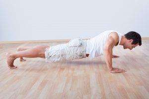 Young Man Performs Pushup On Hardwood Floor